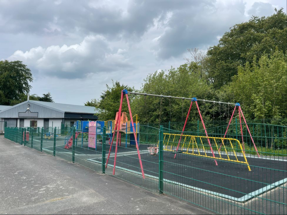 A playground with swings and a play structure at a school