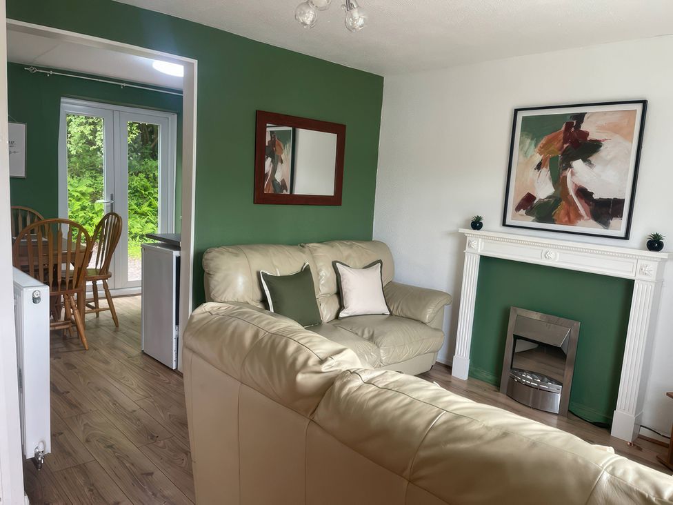 A living room with a sofa and fireplace at Eirlys in Caeathro near Caernarfon