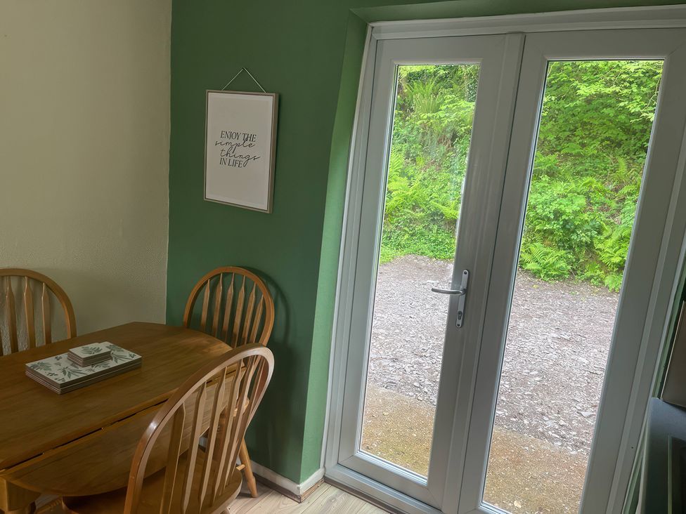 A dining room with a table and chairs at Eirlys Caeathro near Caernarfon