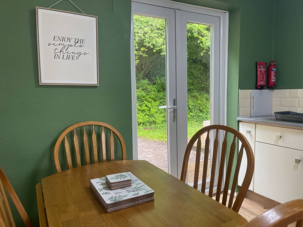 A kitchen with a table and chairs at Eirlys in Caeathro near Caernarfon