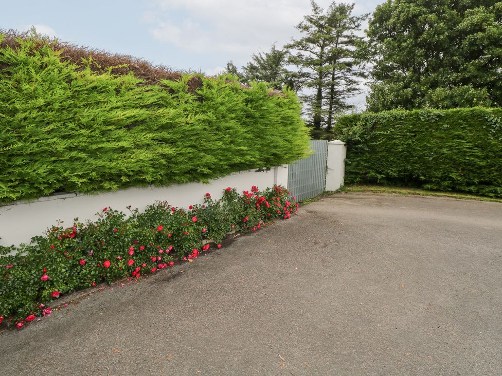 An outdoor area with a hedge and flower bed at Churchfield House, Moygownagh near Crossmolina, County Mayo