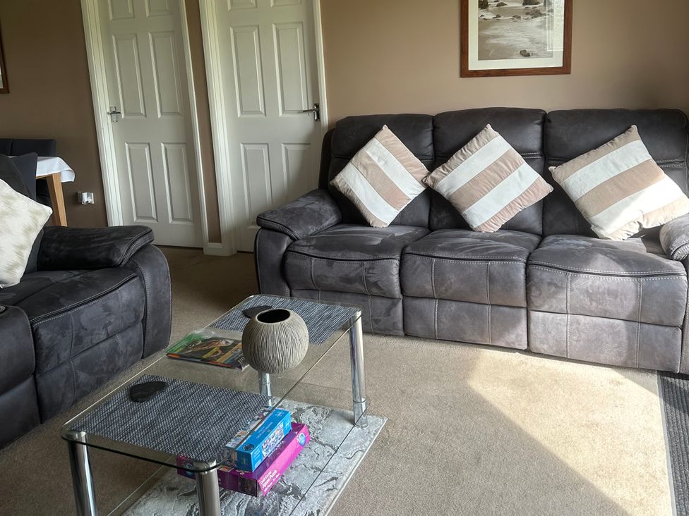 A living room with a sofa and a coffee table at Watergate Bay in Liskeard