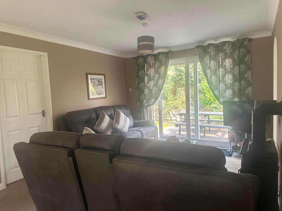 A living room with a sofa and television at Watergate Bay in Liskeard
