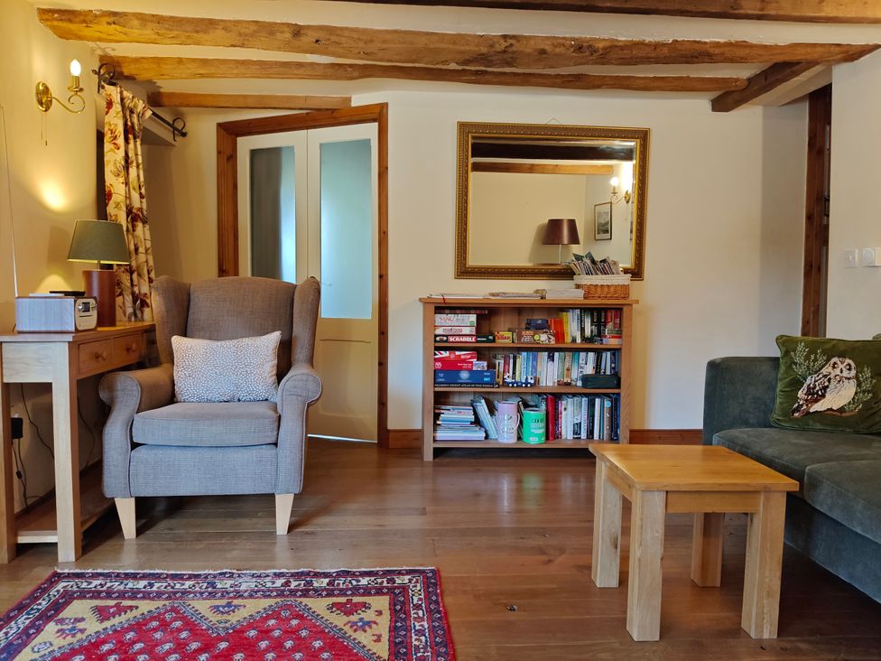 A living room with an armchair and bookshelf at Green Farm Stables in Hognaston near Carsington Water