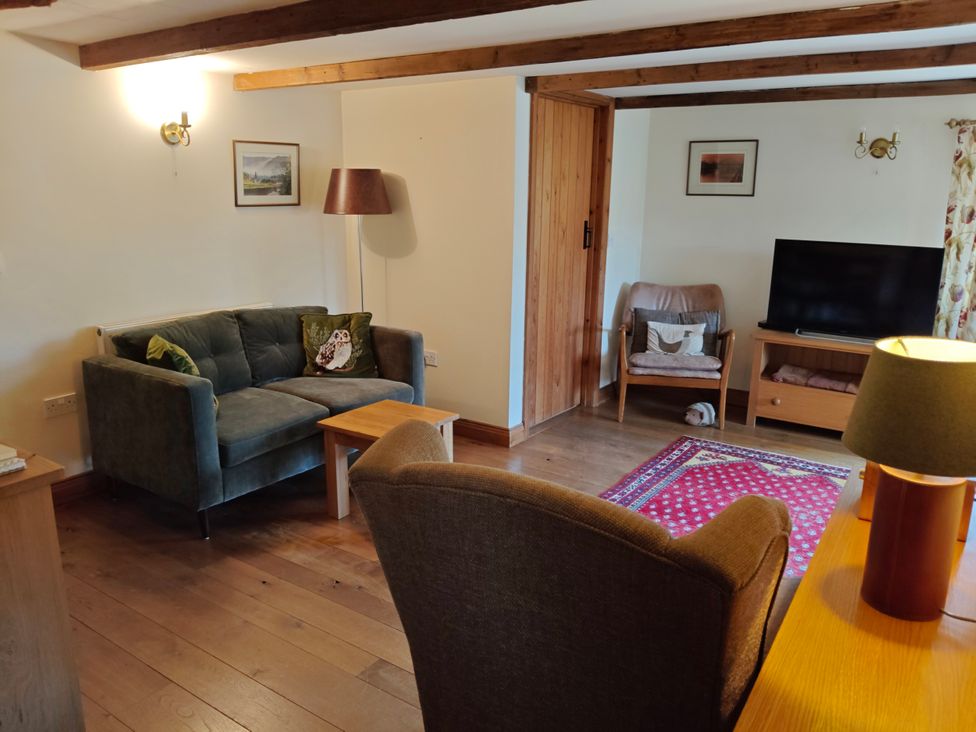 A living room with a sofa and television at Green Farm Stables in Hognaston near Carsington Water