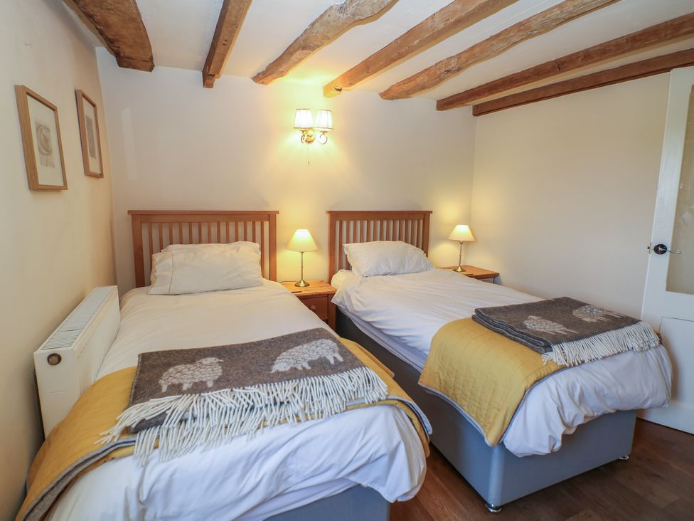 A bedroom with two single beds and bedside tables at Green Farm Stables Hognaston near Carsington Water