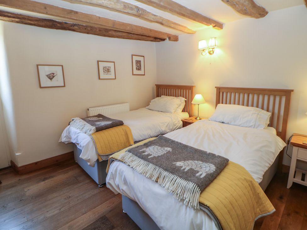 A bedroom with two beds and framed artwork at Green Farm Stables Hognaston near Carsington Water