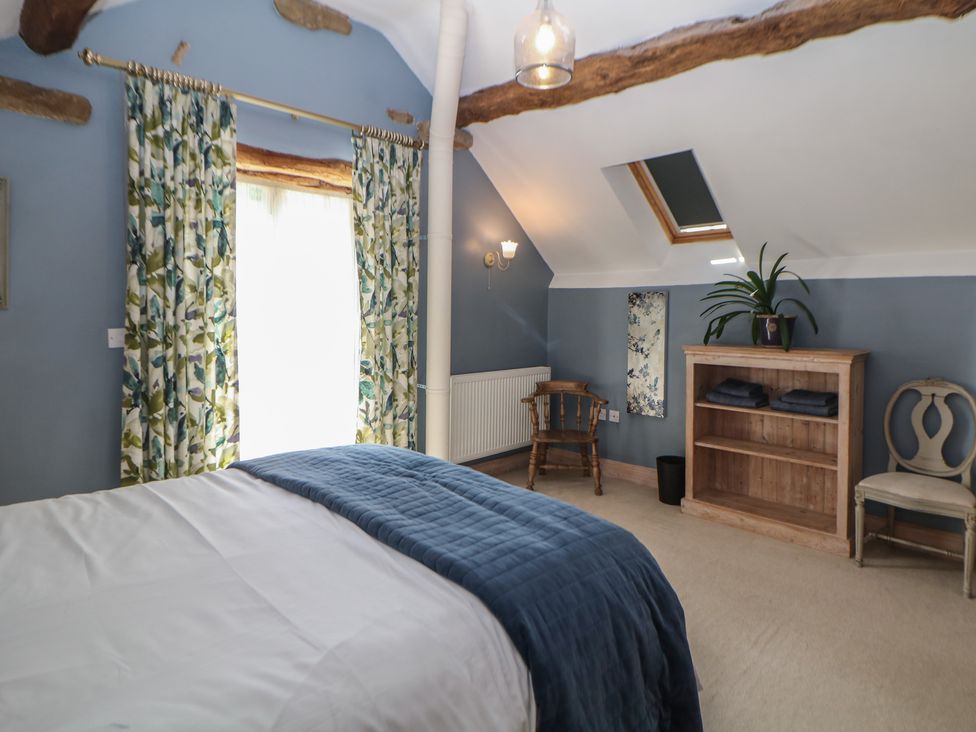 A bedroom with a bed and shelf at Green Farm Stables in Hognaston near Carsington Water