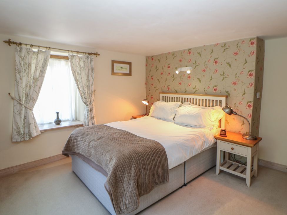 A bedroom with a bed and bedside table at Green Farm Stables near Hognaston near Carsington Water