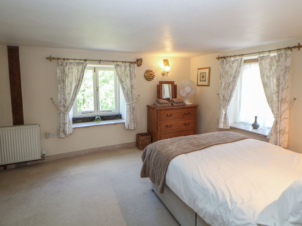 A bedroom with a bed and dresser at Green Farm Stables in Hognaston near Carsington Water