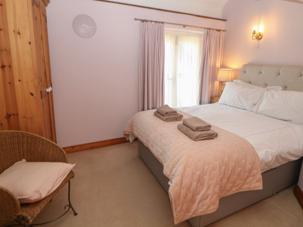 A bedroom with a bed and wardrobe at Green Farm Stables in Hognaston near Carsington Water