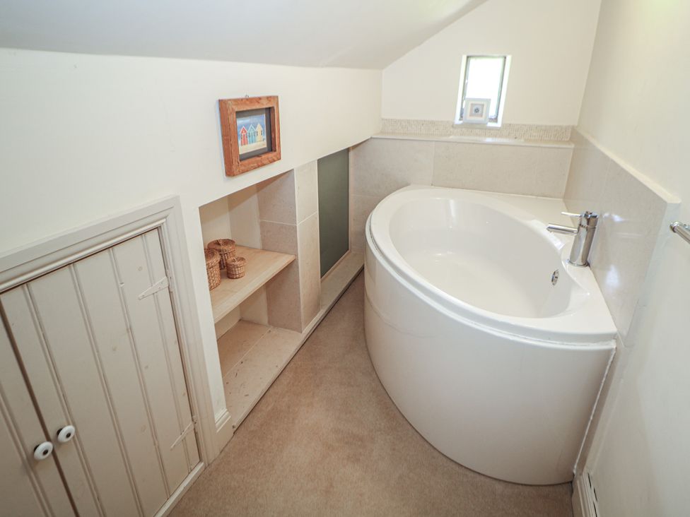 A bathroom with a bath tub and sink at Green Farm Stables in Hognaston near Carsington Water