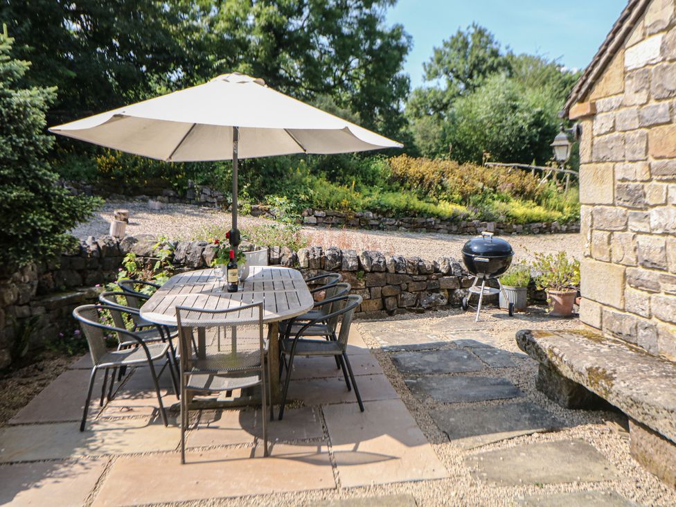 An outdoor seating area with a table and chairs at Green Farm Stables in Hognaston near Carsington Water