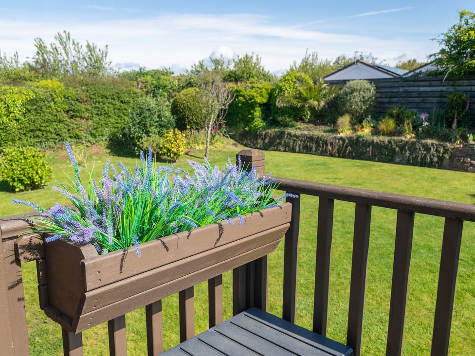 A garden with a lavender flower box and green lawn at Garden View Apartment in Kingsbridge