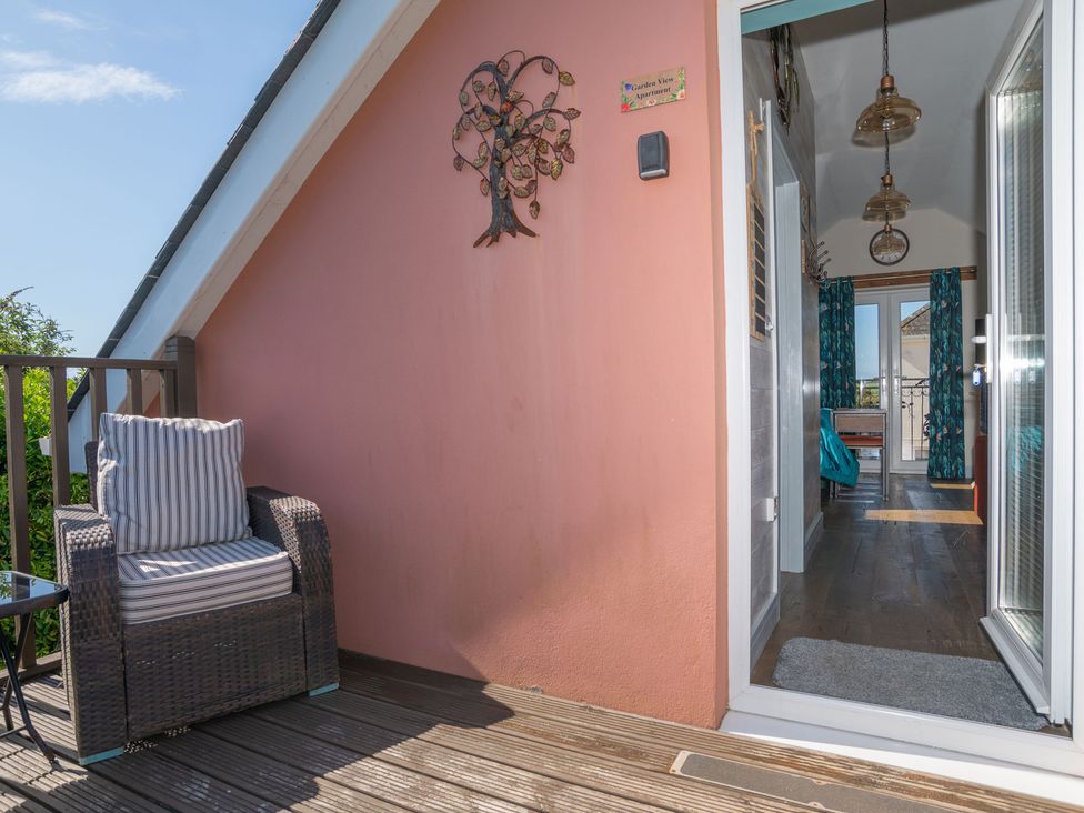 A balcony with a chair and table at Garden View Apartment in Kingsbridge