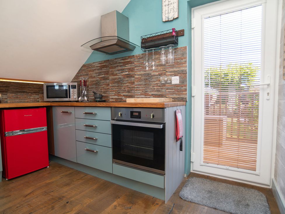 A kitchen with a red refrigerator and a microwave at Garden View Apartment in Kingsbridge