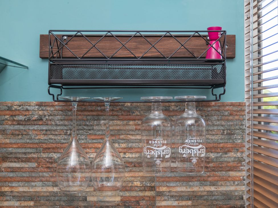 A kitchen with glass rack and hanging wine glasses at Garden View Apartment in Kingsbridge
