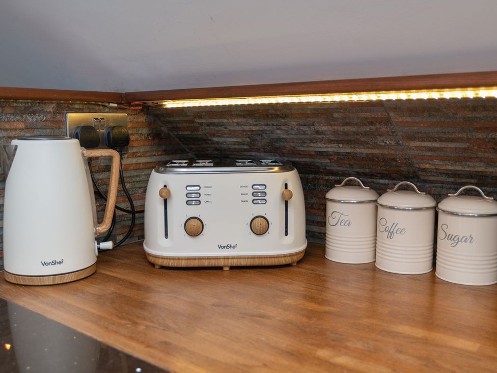 A kettle and toaster with canisters in a kitchen at Garden View Apartment in Kingsbridge