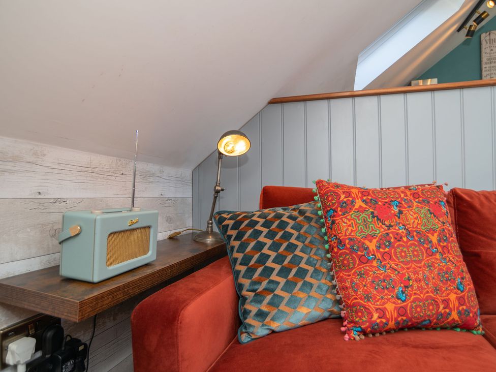 A snug area with a red sofa and decorative pillows at Garden View Apartment in Kingsbridge