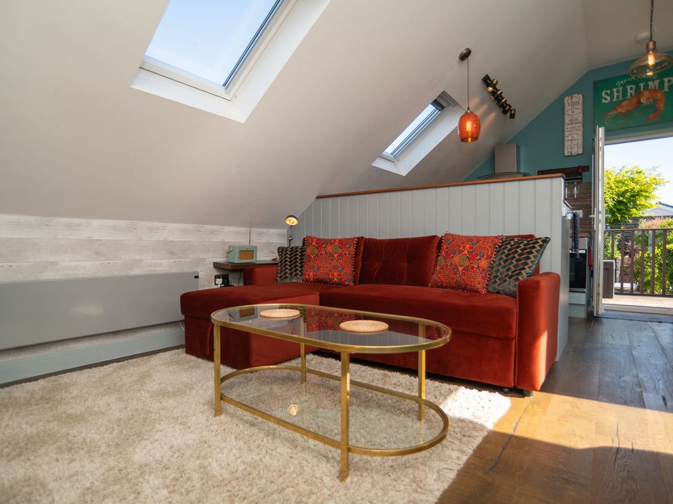 A living room with a red sofa and coffee table at Garden View Apartment in Kingsbridge