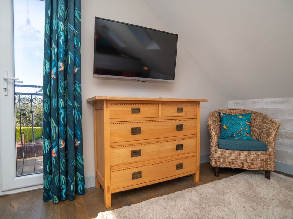 A bedroom with a dresser and TV at Garden View Apartment in Kingsbridge