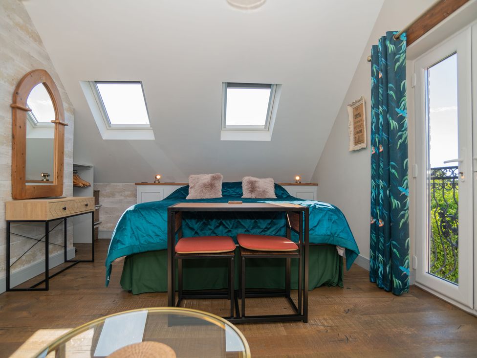 A bedroom with a bed and a table at Garden View Apartment in Kingsbridge