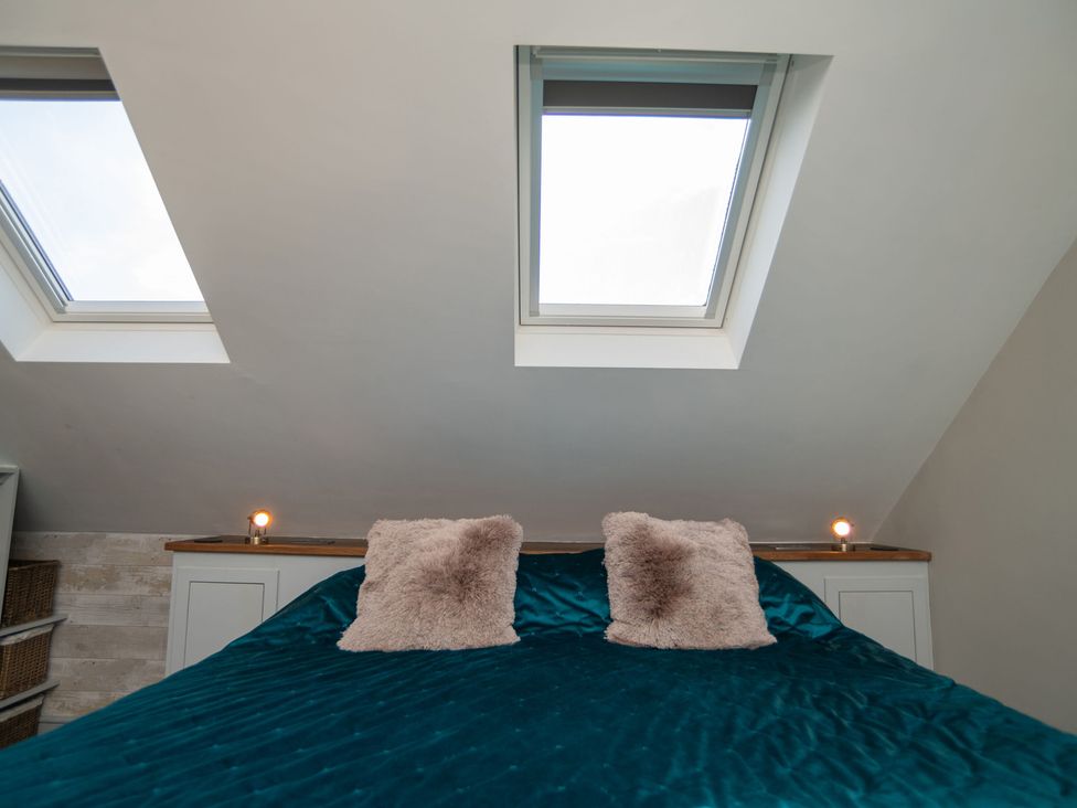 A bedroom with a bed and windows at Garden View Apartment in Kingsbridge