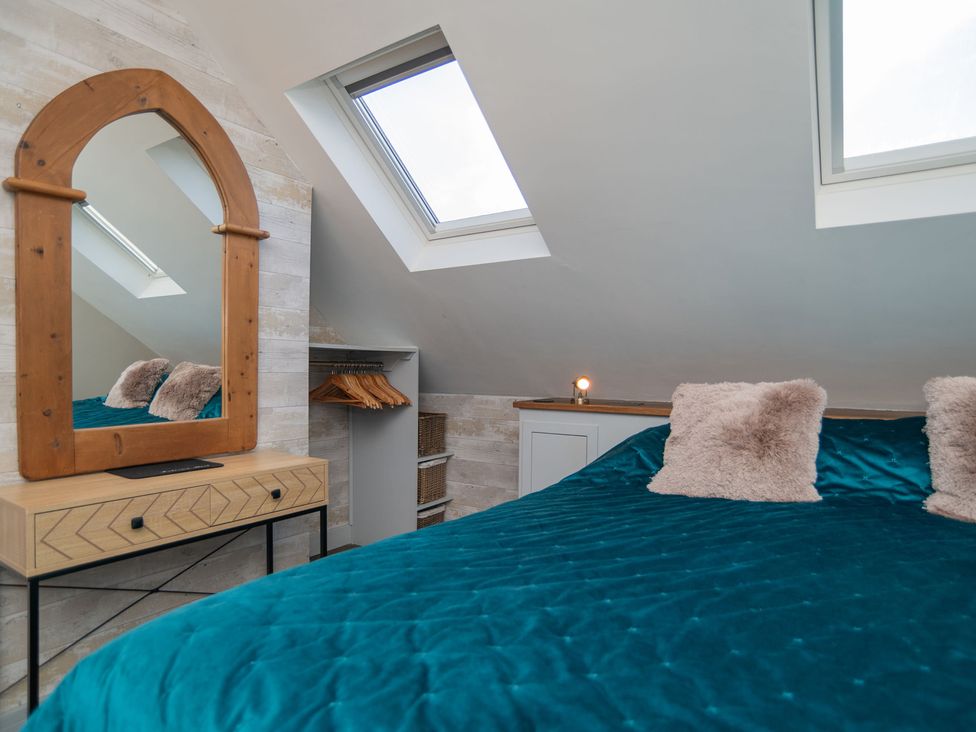 A bedroom with a mirror and bed at Garden View Apartment in Kingsbridge