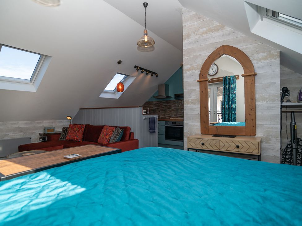A studio with a sofa and kitchen at Garden View Apartment in Kingsbridge
