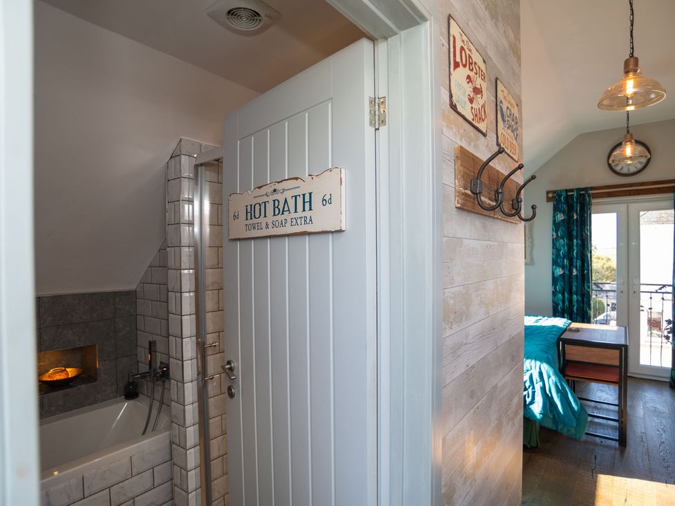 A bathroom with a tub and shower area at Garden View Apartment in Kingsbridge