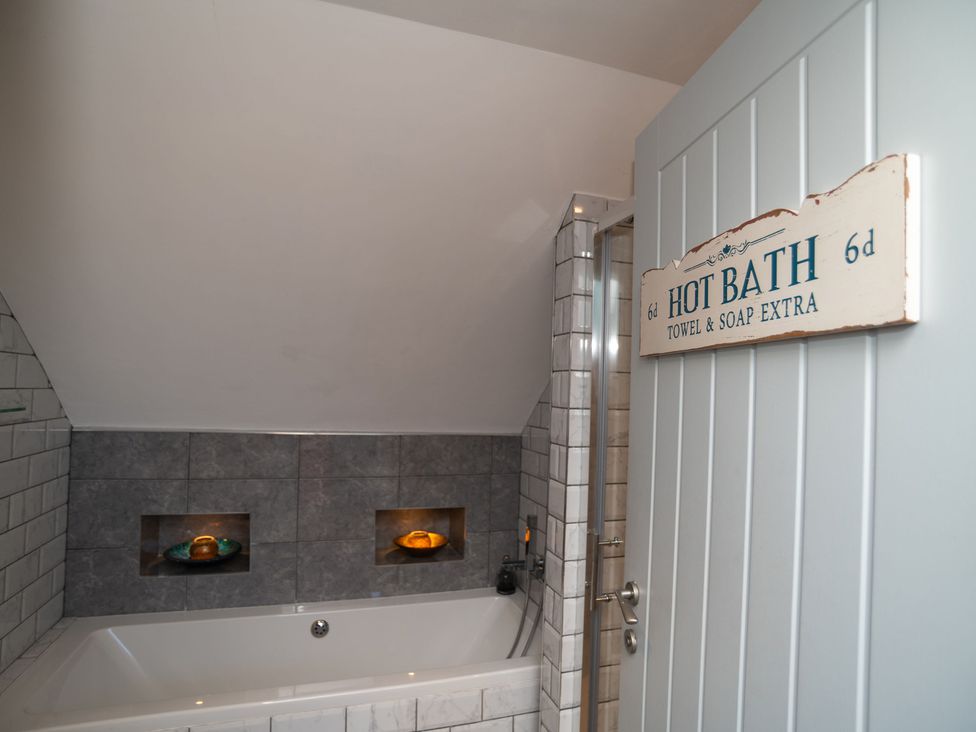 A bathroom with bathtub and shower at Garden View Apartment in Kingsbridge