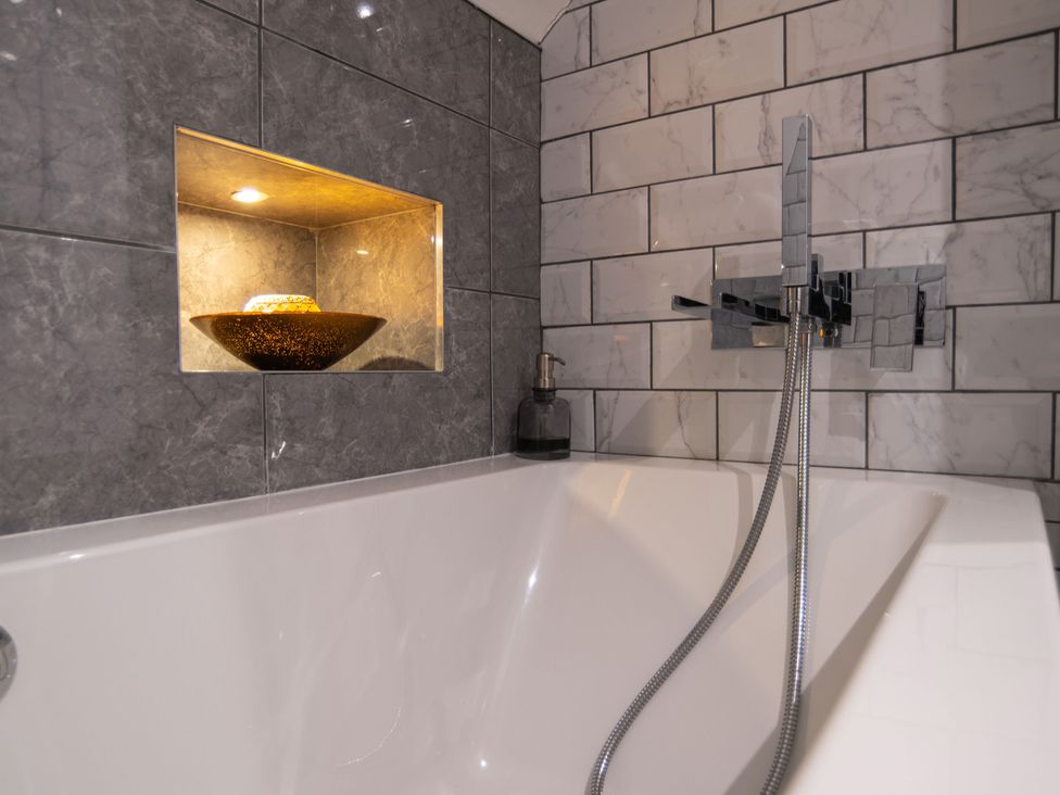 A bathtub with a faucet and decorative bowl in the bathroom at Garden View Apartment in Kingsbridge