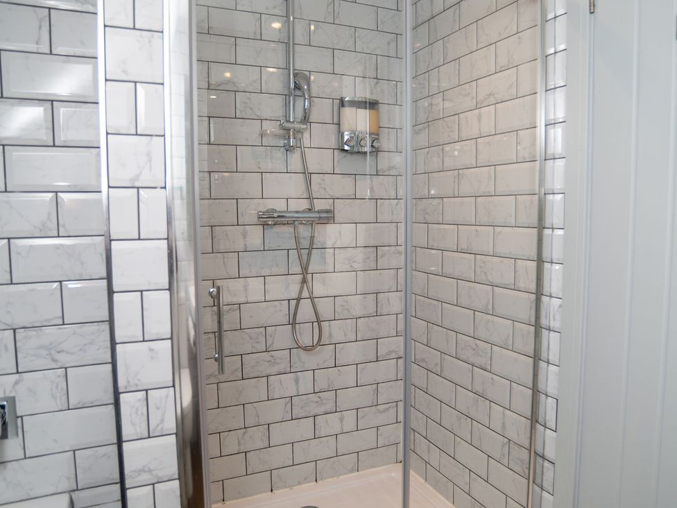A shower area with tiles and a showerhead at Garden View Apartment in Kingsbridge