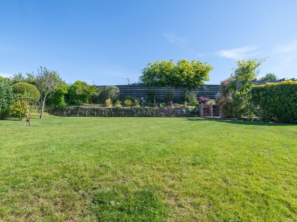 A garden with grass and flower beds at Garden View Apartment in Kingsbridge