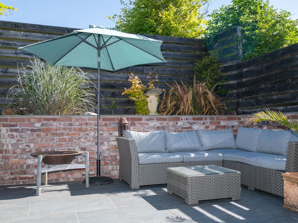 A garden with a sofa and umbrella at Garden View Apartment in Kingsbridge