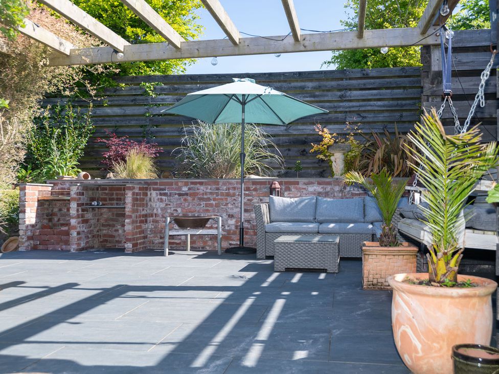 A garden area with an outdoor sofa and umbrella at Garden View Apartment in Kingsbridge