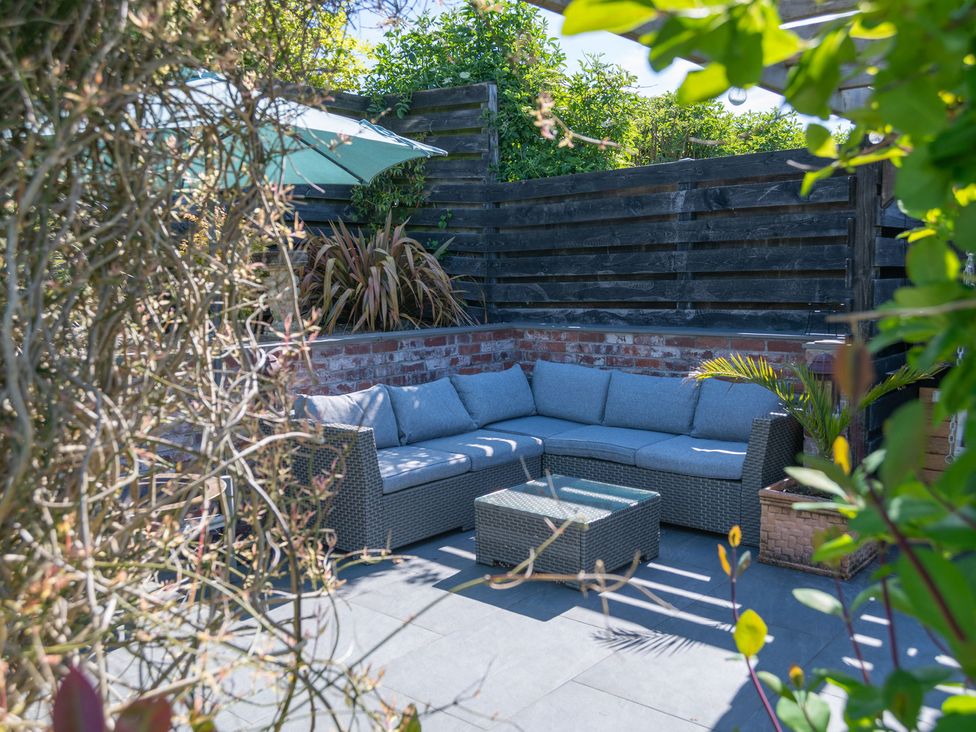 A garden with a couch and coffee table at Garden View Apartment in Kingsbridge