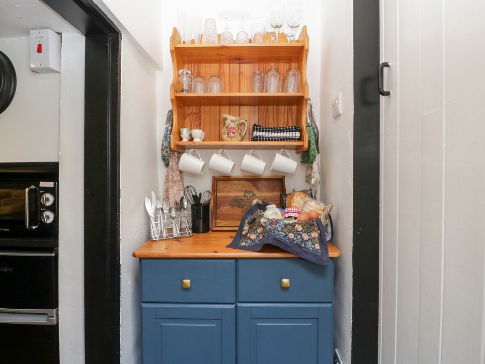 A kitchen area with a cupboard and shelf at Avonmede in Tewkesbury