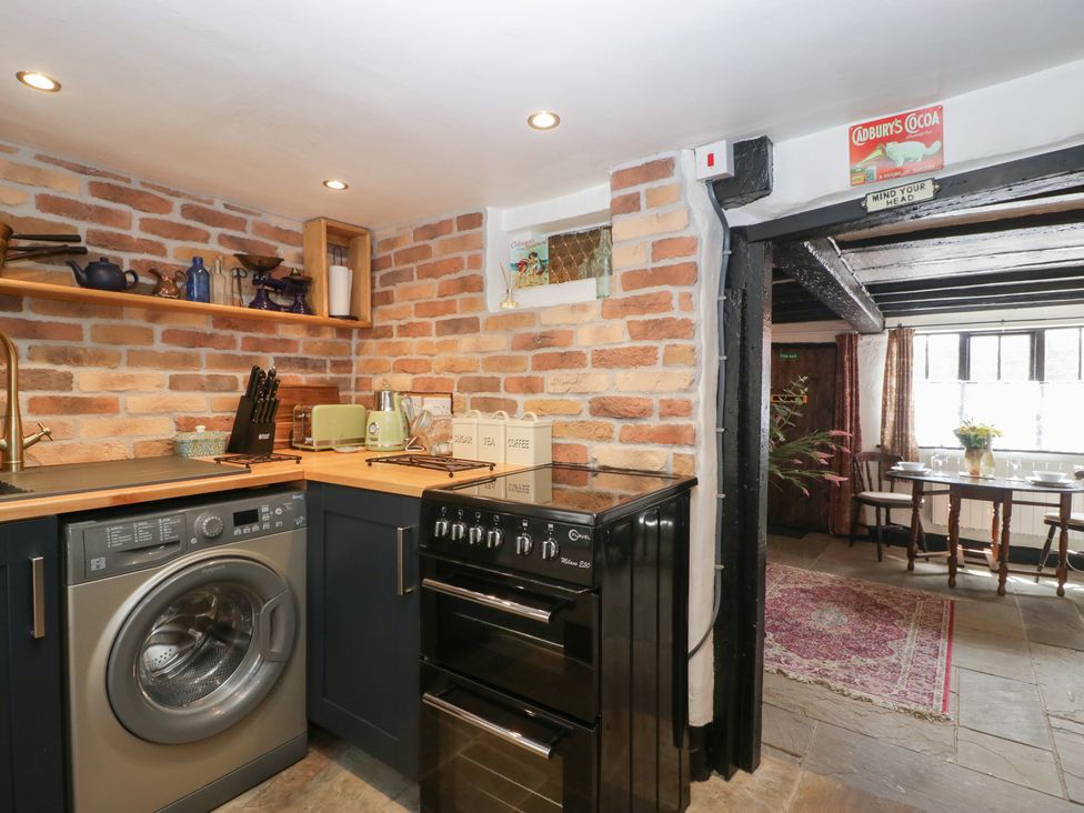 A kitchen with appliances and shelves at Avonmede in Tewkesbury