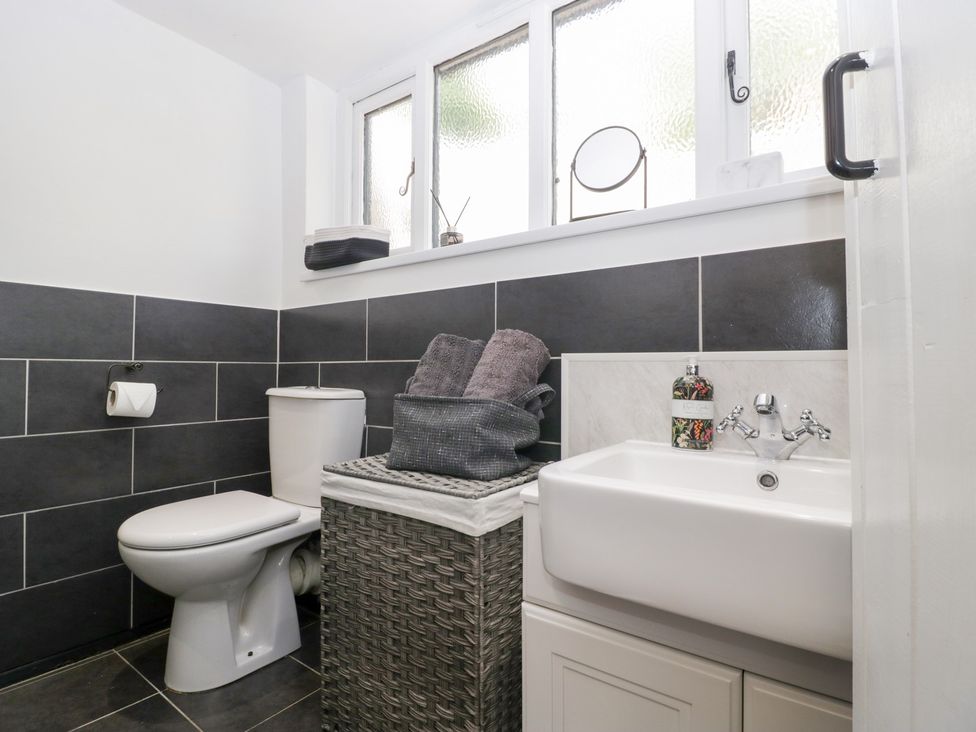A bathroom with a toilet, sink, and towels at Avonmede in Tewkesbury
