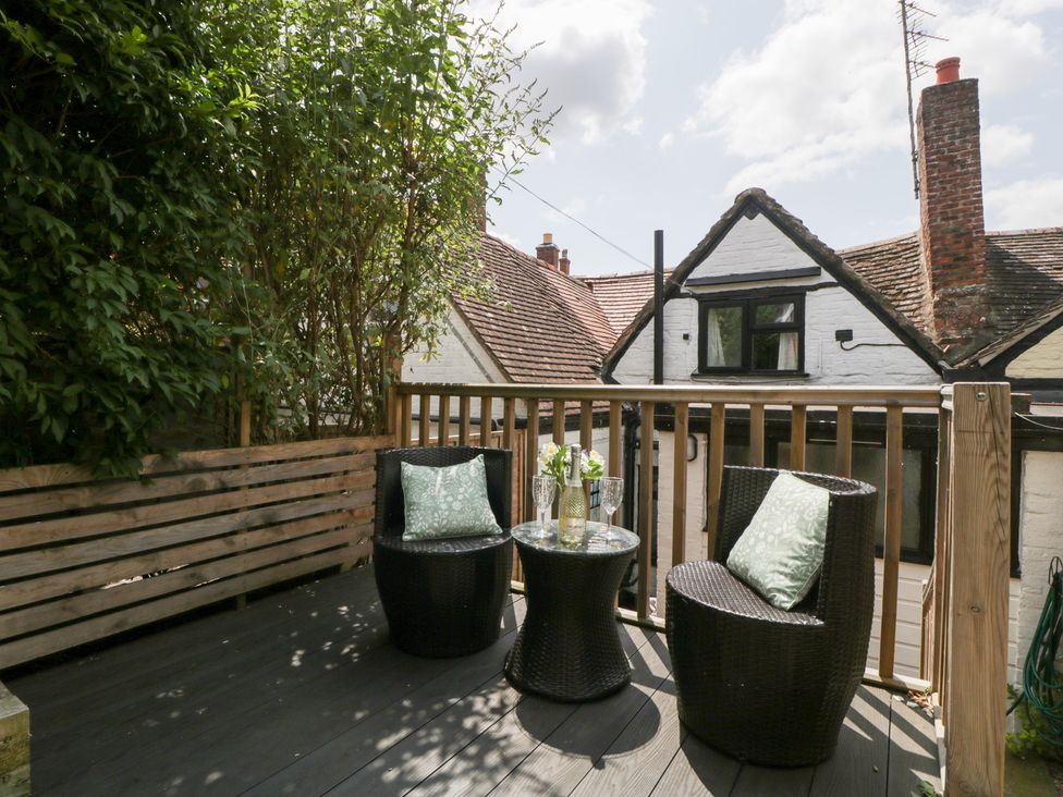 A deck area with chairs and a table at Avonmede in Tewkesbury