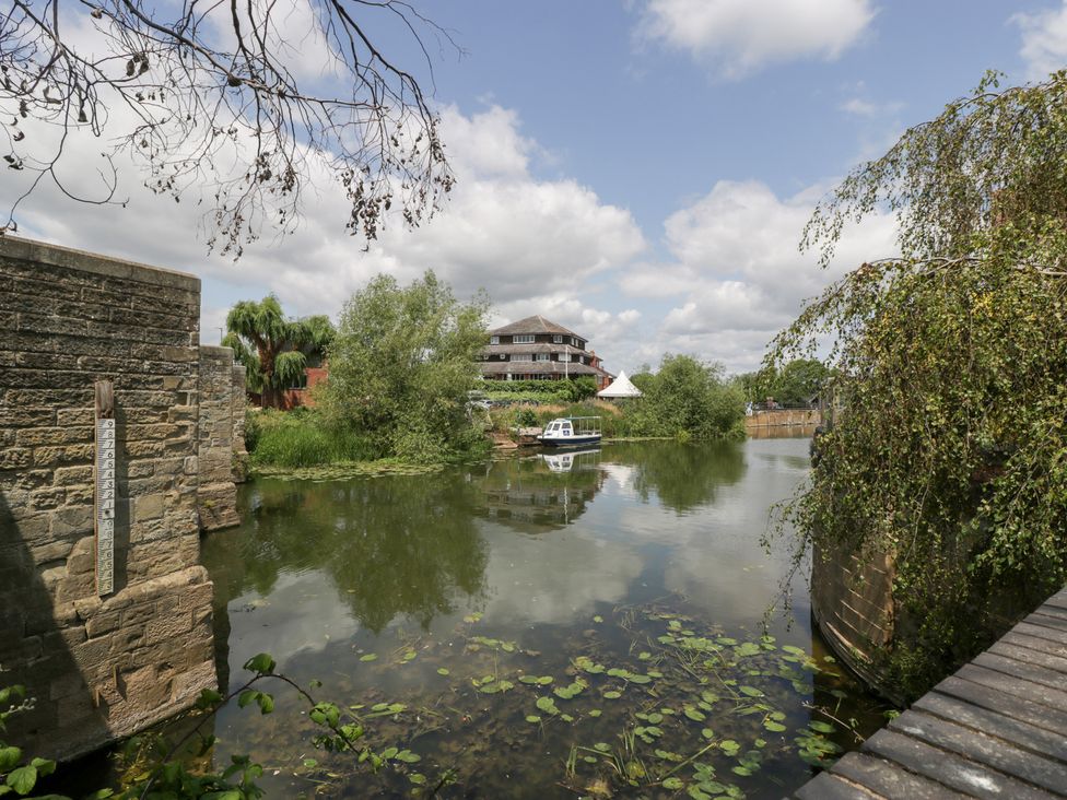 A river scene with a bridge and boat at Avonmede in Tewkesbury