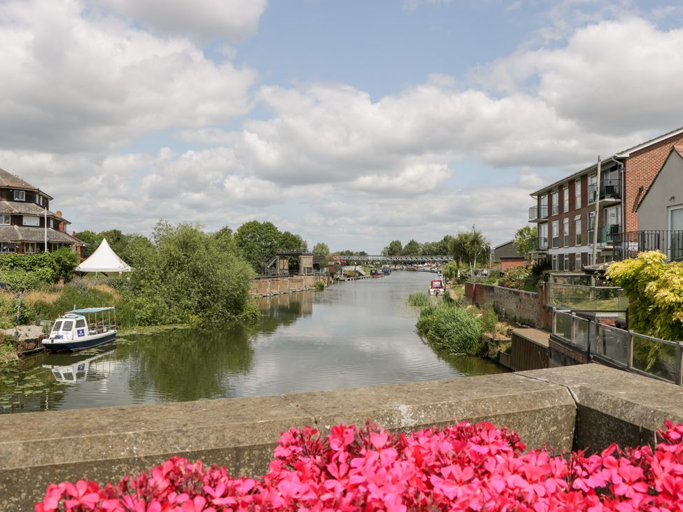 A river with boats and buildings along the bank at Avonmede in Tewkesbury