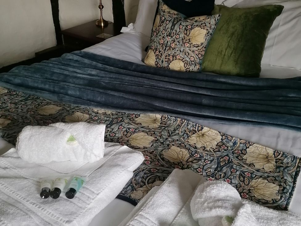 A bedroom with blankets and towels at Avonmede in Tewkesbury