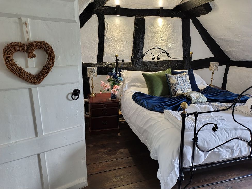 A bedroom with a bed and bedside table at Avonmede in Tewkesbury