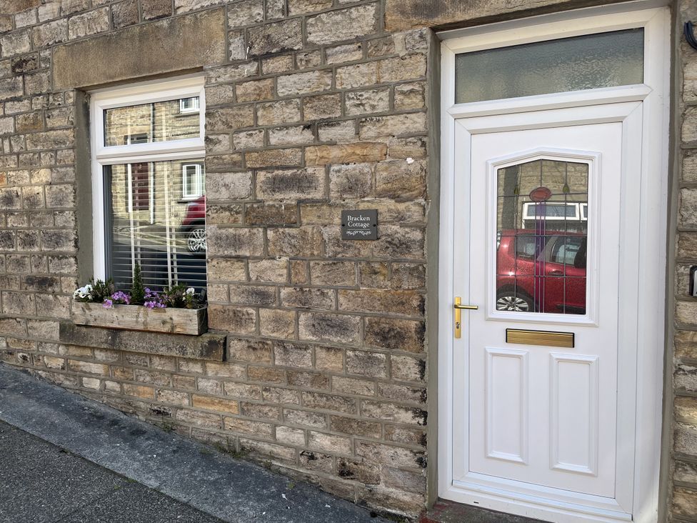 An exterior view of Bracken Cottage with a door and window in Stanhope