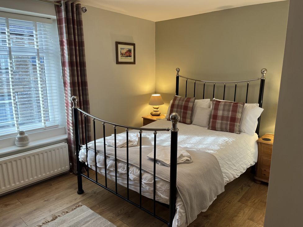 A bedroom with a bed and lamp at Bracken Cottage Stanhope