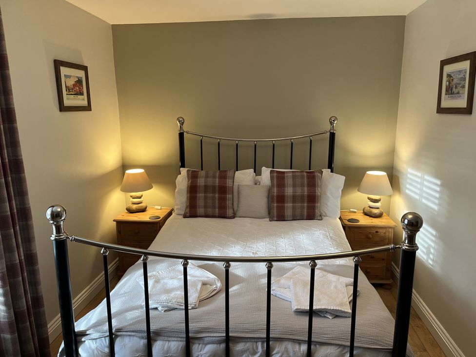 A bedroom with a bed and bedside tables at Bracken Cottage in Stanhope