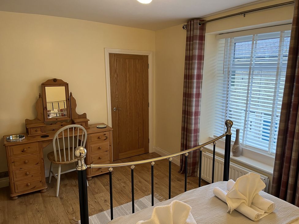 A bedroom with a bed and a dressing table at Bracken Cottage in Stanhope