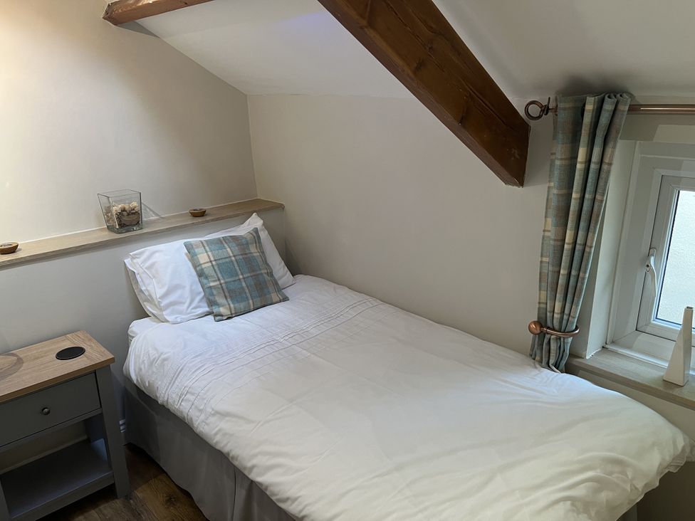 A bedroom with a bed and nightstand at Bracken Cottage in Stanhope